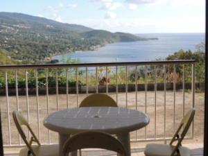 a table and chairs on a balcony with a view of the ocean at Résidence cabré in Bouillante