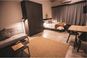 um quarto de hotel com uma cama e um sofá em Blackbrick Sandton One em Joanesburgo