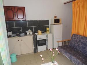 a small kitchen with a stove and a refrigerator at Résidence cabré in Bouillante