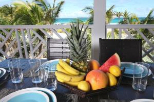 a plate of fruit on a table on a balcony at Princess Anouk Beachfront Orient Bay Deluxe 3 BDR in Orient Bay