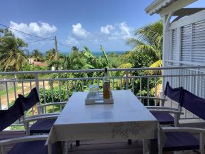 a table on a balcony with a view of the ocean at VILLA ALIZEE APPARTEMENT N°6 in Sainte-Rose