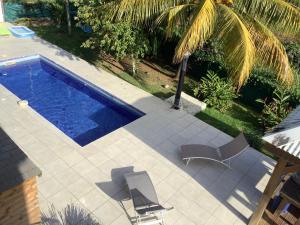 an overhead view of a swimming pool with two chairs at VILLA ALIZEE APPARTEMENT N°6 in Sainte-Rose