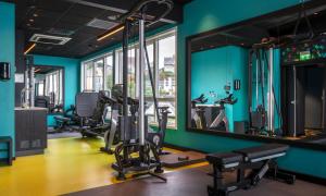 a gym with tread machines and a mirror at Thon Hotel Harstad in Harstad