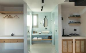 a bathroom with a sink and a mirror at Terra Nera Suites in Perivolos