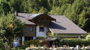 a house with a balcony on top of it at Gästehaus Bergkristall in Wallgau