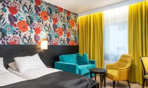 um quarto de hotel com uma cama e uma cadeira em Thon Hotel Harstad em Harstad