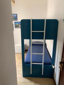 a blue bunk bed with a ladder in a room at La maison du vent in Marettimo