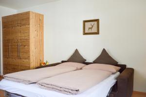 una cama con almohadas en una habitación en Niedermairhof, en Falzes