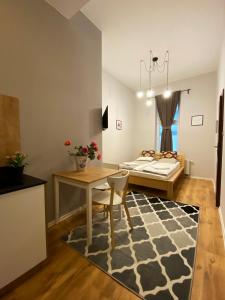 a bedroom with a bed and a table and a rug at Smart Rooms for Rent in Kraków