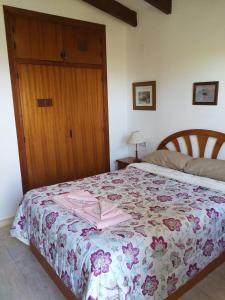 1 dormitorio con 1 cama con colcha de flores en El Rincón de la Quinta en Calpe