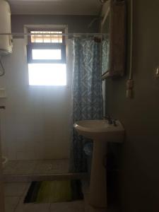 a bathroom with a sink and a toilet and a window at Riyadh - en el bosque a metros de la playa in Rincón de los Oliveras