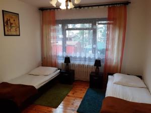 2 camas individuais num quarto com uma janela em Forest Villa em Susiec