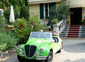 a green car parked in front of a house at Hotel Giglio in Salsomaggiore Terme