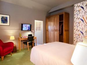 a bedroom with a bed and a red chair and a desk at Fab House - Les Maisons Fabuleuses in Senlis