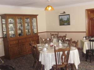 a dining room with a table and a china cabinet at Devanes B&B in Dingle