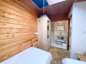 a bedroom with a wooden wall with a bed and a sink at Gezellige vakantiewoning dichtbij centrum Domburg DO20 in Domburg