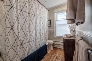 a bathroom with a toilet and a tile wall at Haven on the Hill in Portland