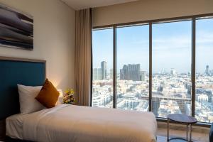 a hotel room with a bed and a large window at Suha Mina Rashid Hotel Apartments in Dubai