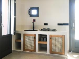 a kitchen with a white counter with a sink at Terra Nera Suites in Perivolos