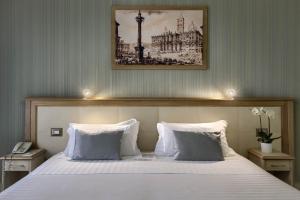 een slaapkamer met een groot wit bed met 2 kussens bij Domus Australia in Rome