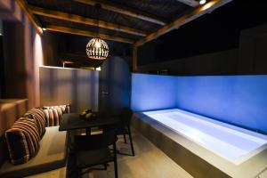 a bathroom with a tub and a table and a chair at Terra Nera Suites in Perivolos
