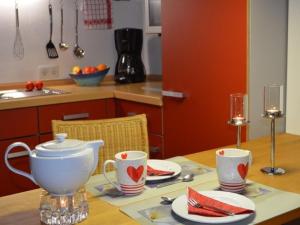 uma cozinha com uma mesa com copos e pratos em Ferienwohnung Omert em Ehrenberg