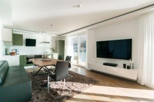 a living room with a dining room table and a television at 10 am See - auf der Sonnenseite in Diemelsee