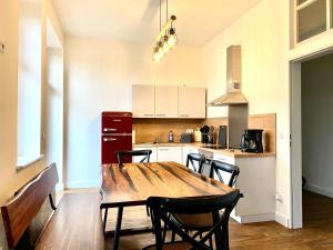 a kitchen with a wooden dining table and chairs at Villa Schomberg in Spremberg