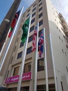 um edifício com bandeiras à sua frente em ماجيك سويت المهبولة 2 Magic Suite ALMahboula 2 em Kuwait