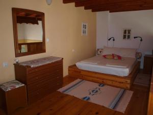 a bedroom with a bed and a dresser and a mirror at Andreas Apartments in Symi