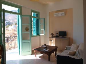 a living room with a couch and a table and a window at Andreas Apartments in Symi