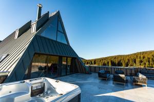 a house with a tub on a roof at Hotel Monti Spa & Wellness in Igman