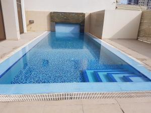uma piscina com água azul num edifício em ماجيك سويت المهبولة 2 Magic Suite ALMahboula 2 em Kuwait