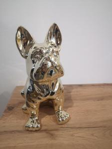 a silver dog statue sitting on a wooden table at Les Cottages Barisiens in Bar-le-Duc