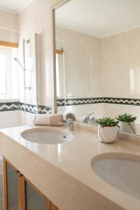 a bathroom with two sinks and a large mirror at Casa do Ar in Sesimbra