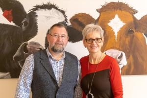 a man and a woman standing in front of a painting of cows at Hermes Hotel Oldenburg in Oldenburg