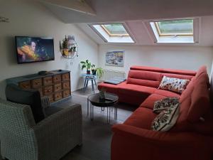 a living room with a red couch and a table at Vakantiehuis Dartien in Exloo