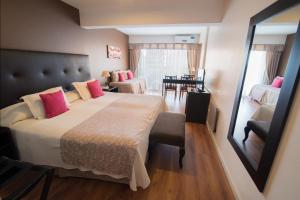 una camera da letto con un grande letto con cuscini rosa di Gran Hotel Continental a Mar del Plata