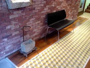 a black chair sitting in a room with a brick wall at Hospedium Hotel Posada De La Luna in Huesca