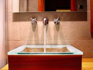 a sink with two faucets on a wall at Hospedium Hotel Posada De La Luna in Huesca