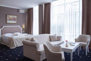 a hotel room with a bed and a couch and a table at City Holiday Resort & SPA in Kyiv