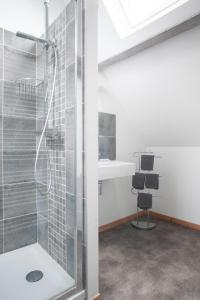 a shower with a glass door in a bathroom at L'Heure Bleue gîtes et chambres d'hôtes in Givenchy-en-Gohelle