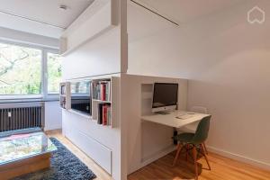 Zimmer mit einem Schreibtisch, einem Computer und einem Bett in der Unterkunft Alster 36 - Exklusives City Apartment in Hamburg