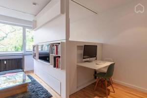 a room with a desk with a computer and a bed at Alster 36 - Exklusives City Apartment in Hamburg