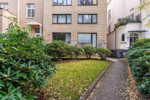 a brick building with a walkway in front of a yard at Alster 36 - Exklusives City Apartment in Hamburg