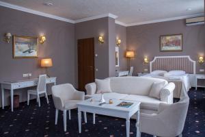um quarto de hotel com um sofá e uma cama em City Holiday Resort & SPA em Kiev