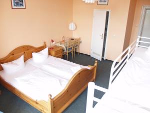 2 Betten in einem Zimmer mit einem Tisch und einem Esszimmer in der Unterkunft Happy Go Lucky Hotel + Hostel in Berlin