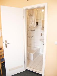 La salle de bains est pourvue d'une douche et d'une baignoire. dans l'établissement Happy Go Lucky Hotel + Hostel, à Berlin