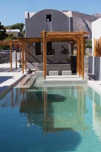 a house with a swimming pool with a wooden pergola at Terra Nera Suites in Perivolos