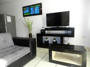 sala de estar con sofá y TV de pantalla plana en Departamento Marifer, en Tacna